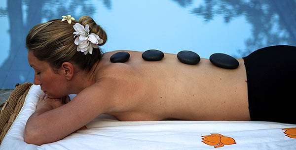 Hot stone massage by the pool on holiday